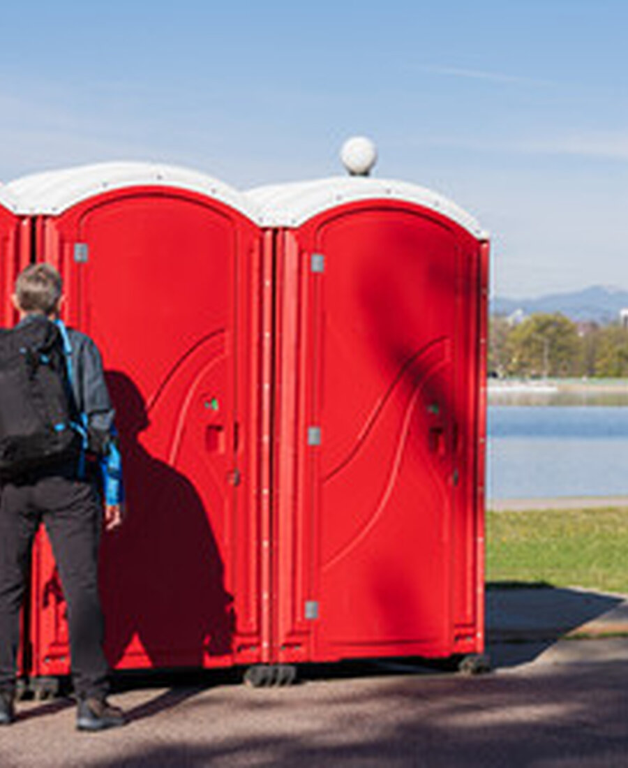 Portable restrooms set up at a public park near a lake